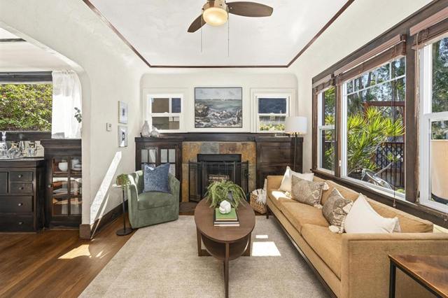 Craftsman living room with a fireplace, built-in cabinets, wood trim and a tan sofa