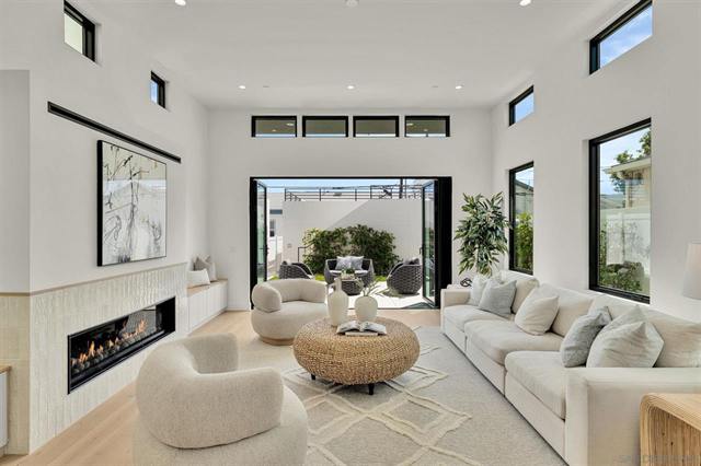 Open living room with a linear fireplace, clerestory windows and sliding doors